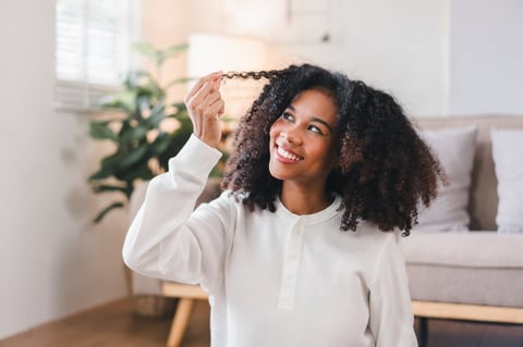 Woman playing with curly hair at home